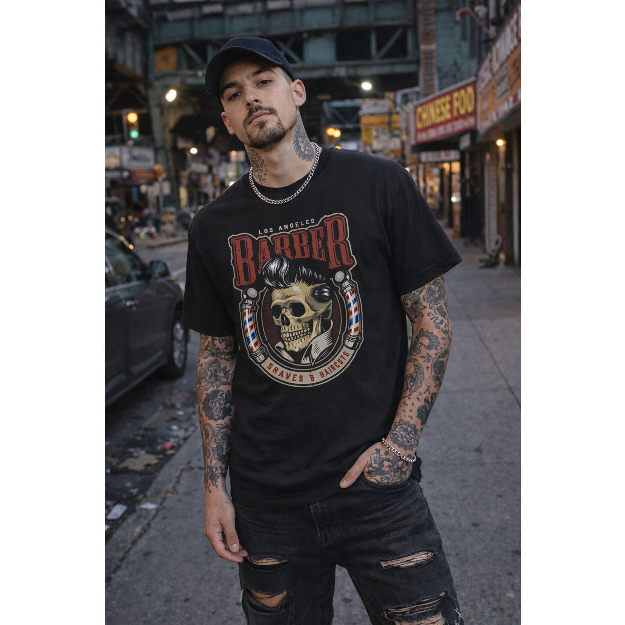 Man wearing a black t-shirt with a skull design and 'Barber' text on a city street.