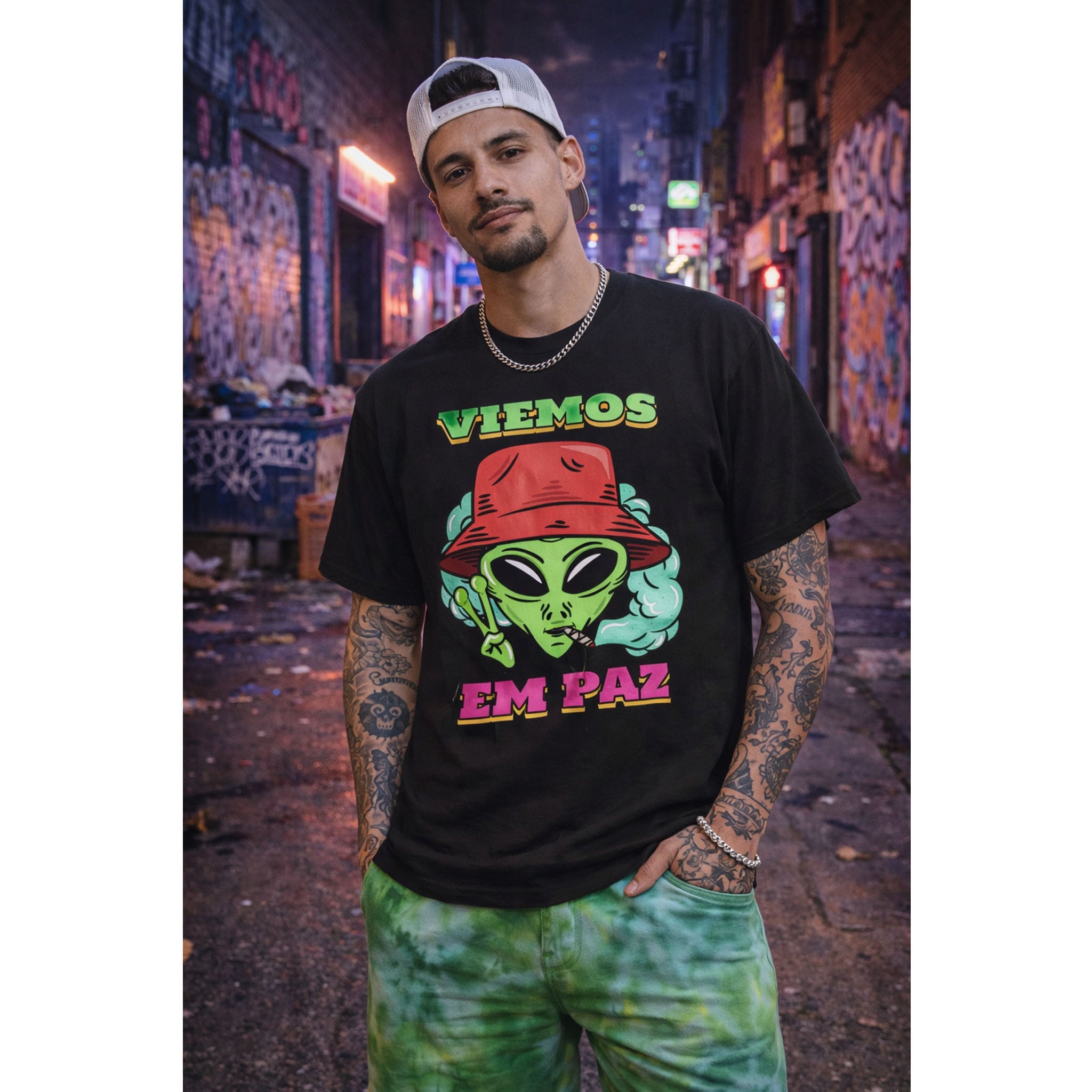 Person wearing a black t-shirt with an alien graphic and text, standing in an urban alleyway – Bamerix